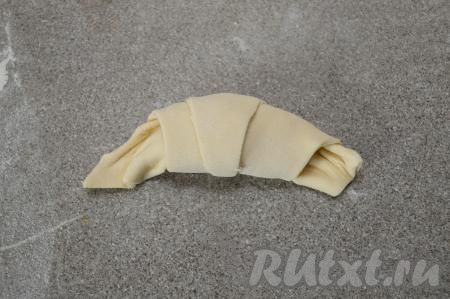Свернуть треугольник в рулет, начиная со стороны с начинкой. У вас получится заготовка круассана. Аналогично сформировать ещё три заготовки.