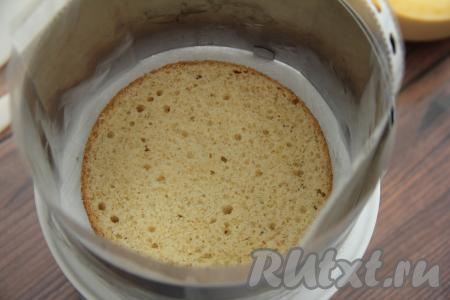 Остывший бисквит разрезать на три коржа. На дно&nbsp; формы выложить первый корж. Так как корж у нас диаметром 16 сантиметров, а выкладываем мы его в форму диаметром 18 сантиметров, то часть суфле у нас будет снаружи торта. Поэтому следует выстелить бортики формы ацетатной плёнкой или файликами (чтобы застывшее суфле легче отставало от бортиков).