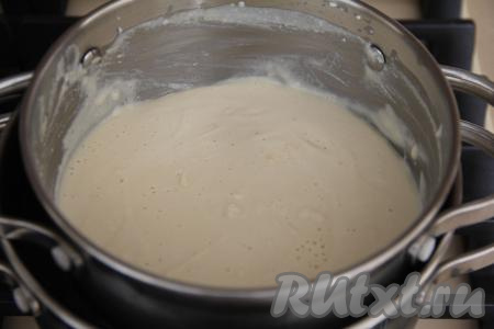 Теперь нужно кастрюлю с творожно-яичной массой поставить на водяную баню. Для этого нужно взять кастрюлю большего диаметра, чем кастрюлька с творожно-яичной массой. В эту большую кастрюлю влить воду, поставить на огонь и довести воду до кипения, уменьшить огонь. Поверх кастрюли с кипящей водой поставить кастрюльку с творожно-яичной массой. Кастрюлька с творожно-яичной массой не должна находиться в воде, а должна всего лишь слегка касаться поверхности воды. Варить творожно-яичную массу 15 минут, постоянно помешивая. Масса должна полностью расплавиться.