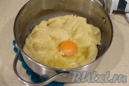 Начать в слегка остывшую заварную массу добавлять по одному яйцу, тщательно перемешивая. Я перемешивала на низкой скорости миксера.
