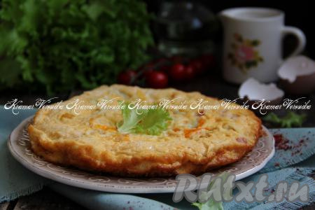 Пышный, пористый, нежный омлет с колбасой и помидорами перевернуть из чаши мультиварки на плоскую тарелку.