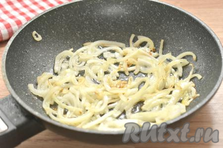 Вливаем на сковороду растительное масло, прогреваем его. Выкладываем в горячее масло полукольца лука, обжариваем 3 минуты, периодически перемешиваем. Лук должен стать мягким.