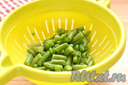 Параллельно с обжаркой мяса нужно отварить фасоль. Если у вас свежая фасоль, тогда её нужно промыть водой, затем у стручков отрезать "кончики" с двух сторон, после этого разрезать стручки на 3-4 части. Подготовленную свежую (или замороженную) стручковую фасоль выкладываем в кипящую воду. После закипания варим 7-8 минут на небольшом огне (фасоль должна стать достаточно мягкой, но при этом развариться она не должна). Отваренную стручковую фасоль откидываем после варки на дуршлаг, обдаём холодной водой.