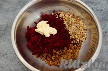 В миску с натёртой свеклой выложить нарубленные грецкие орехи, обсушенный изюм и майонез.