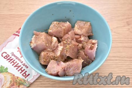 Свинину промываем водой, обсушиваем, нарезаем на средние кубики (примерная длина кусочка - 3 сантиметра), складываем в миску. К мясу добавляем приправу для свинины и соевый соус, перемешиваем и оставляем мариноваться при комнатной температуре минут на 40-45.