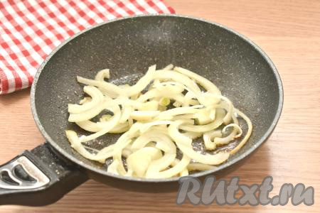 Когда все отбивные будут пожарены, займёмся луком. Нарезаем очищенную луковицу на полукольца. Выкладываем лук на ту же сковороду, в которой готовились отбивные, и обжариваем его на среднем огне в течение 3-4 минут (до мягкости), периодически перемешивая.