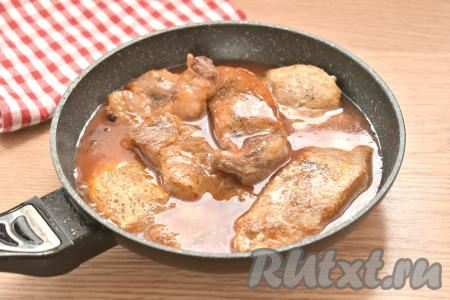 Для приготовления томатного соуса соединяем в небольшой ёмкости 1,5 столовых ложки томатной пасты и 150 миллилитров тёплой кипячёной воды, очень хорошо перемешиваем. Обжаренные отбивные из свинины возвращаем на сковороду к луку и заливаем подготовленным томатным соусом.