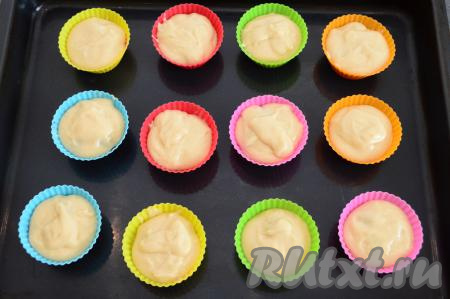 Сверху выложить ещё тесто, заполняя формы на 3/4 объёма (я сверху выкладывала по 0,5 столовой ложки теста, полностью накрывая ягоды). Вишня у нас получится внутри маффинов. Всего у меня получилось сформировать 12 маффинов с начинкой из замороженной вишни.