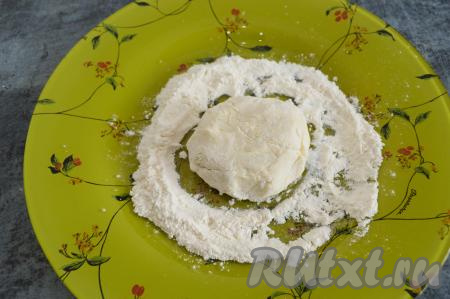 Зрительно разделить творожно-банановую массу на 4 части. Вначале из одной части теста влажными руками сформировать округлый сырник. На тарелку насыпать 1-2 столовых ложки муки, обвалять заготовку сырника в муке со всех сторон.