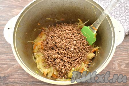 Гречку, если нужно, перебираем, удаляя испорченные зёрна, затем промываем крупу под проточной водой, перекладываем в сито, чтобы с гречки стекла лишняя вода. После того как капуста протушится с мясом 10 минут, добавляем промытую гречку.