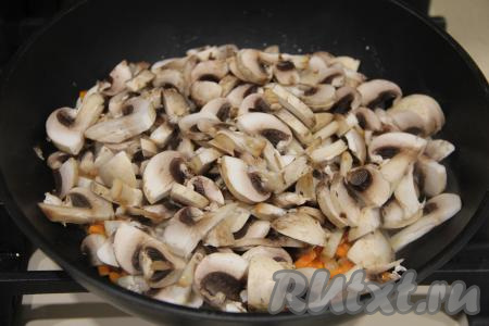 Шампиньоны нарезать на пластинки (если вы готовите с отваренными лесными грибами, тогда крупные грибочки нужно будет нарезать на части), добавить в сковороду к обжаренным овощам, перемешать.