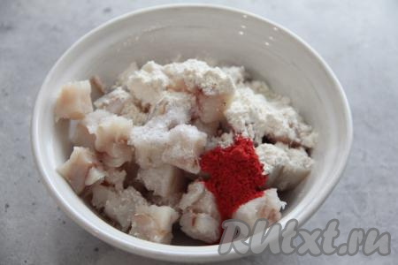 Если филе минтая заморожено, его нужно разморозить. Филе минтая промыть водой, обсушить. Нарезать рыбное филе на кубики размером 1,5х1,5 сантиметра, переложить в миску. Добавить к рыбке соль, муку и специи (я использовала копчёную паприку).