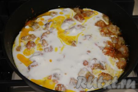 Влить получившийся сметанный соус в сковороду с филе минтая и морковью.