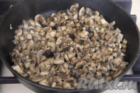 Обжаренный лук переложить на тарелку, дать ему немного остыть. Шампиньоны промыть, мелко нарезать, выложить в сковороду с маслом и обжаривать минут 15 на среднем огне, периодически помешивая.