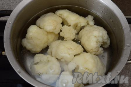 Залить капусту полностью водой и поставить на огонь. После того как вода в кастрюле с капустой закипит, подсолить её по вкусу и уменьшить огонь. Варить капусту с момента закипания на небольшом огне 5-6 минут. Соцветия должны стать мягкими и легко прокалываться ножом, но при этом они должны хорошо держать форму и не быть не разваренными. С отваренной цветной капусты слить воду и оставить её остывать.