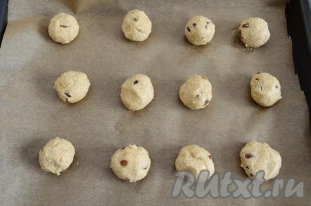 Руками, смоченными водой, сформировать из теста шарики размером с грецкий орех, выкладывать их на противень, застеленный пергаментной бумагой, на расстоянии друг от друга. Всего получилось 12 заготовок печенья.