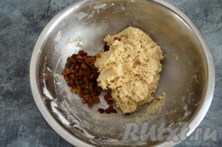 Добавить измельчённые овсяные хлопья в тесто и перемешать. Тесто должно стать комковатым, достаточно густым, оно будет липнуть к рукам. Всыпать изюм в тесто.