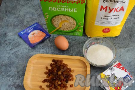 Подготовить продукты для приготовления домашнего овсяного печенья с изюмом. Сливочное масло должно быть комнатной температуры, поэтому из холодильника его нужно достать минут за 20-30 до начала замешивания теста. Изюм тщательно промыть водой, затем переложить в глубокую тарелку, залить полностью кипятком и оставить минут на 5, затем воду слить и обсушить изюм, выложив его в один слой на бумажное полотенце (или салфетку).