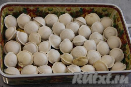 В жаропрочную форму выложить пельмени (у меня - замороженные пельмени) в один слой.