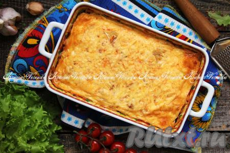 Готовую запеканку достать из духовки, разделить на части и подать к столу. Сочетание пельменей и сырно-сметанной заливки - очень удачное, блюдо приобретает нежный вкус и при этому получается сытным.