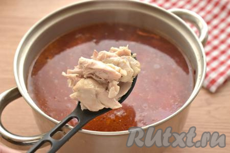 Отделяем остывшие куриные ножки от костей и кожи, затем мясо нарезаем на кусочки. Сразу после добавления тушёных овощей выкладываем в кастрюлю нарезанное мясо. Даём борщу закипеть, а после этого варим на небольшом огне 5-7 минут.