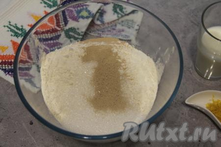 В достаточно глубокую миску просеять муку, добавить сухие дрожжи, сахар и соль, перемешать.