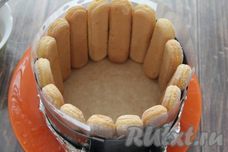 Бока формы для выпечки (я взяла форму диаметром 16 сантиметров) заранее выстелить ацетатной плёнкой (или файликами). Поставить по краю бортика печенье "Савоярди". Если такого печенья нет, можно обойтись и без него (то есть торт будет полностью состоять из мусса, приготовленного из клубники, сливок и желатина).