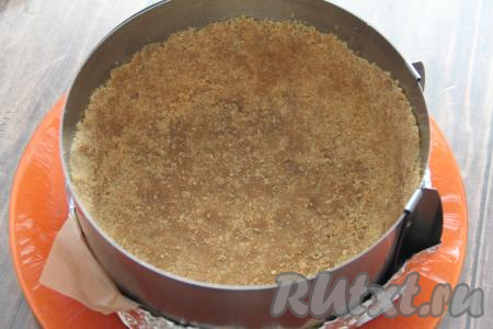 Перемешать получившуюся массу ложкой и выложить в форму. Утрамбовать дно и сформировать высокие бортики. Поставить форму в холодильник до того момента, когда в неё нужно будет выкладывать творожную массу.&nbsp;