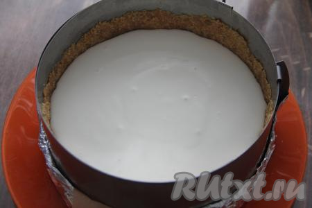 Пробить творожную массу до однородного состояния. По истечении 15 минут набухшую желатиновую смесь прогреть на среднем огне, не прекращая помешивать, до растворения всех кристаллов желатина, но не давая закипеть, снять с огня и влить в чашу блендера с творожной массой, взбить до однородности. Творожная основа для чизкейка получится не густой. Влить творожную основу в форму с основой из печенья и поставить в холодильник на 2 часа (до полного застывания).