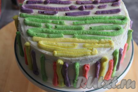 А можно верх торта покрыть взбитыми сливками или крем чизом. В этот раз я решила украсить тортик по-весеннему. Купила готовый сладкий творожный крем, подкрасила его пищевыми красителями и этим кремом обмазала верх и бока торта.