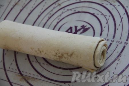 Свернуть два пласта слоёного теста, начиная с узкой стороны, в один рулет. Не нужно плотно сворачивать тесто. Рулет должен получиться не плотным.