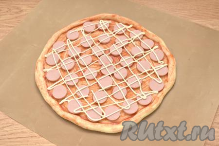 Берём 1 столовую ложку майонеза и наносим на пиццу в виде сеточки.