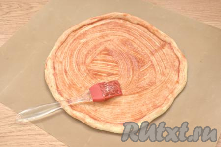 Смазываем получившуюся заготовку для пиццы 1 столовой ложкой кетчупа (или томатного соуса).