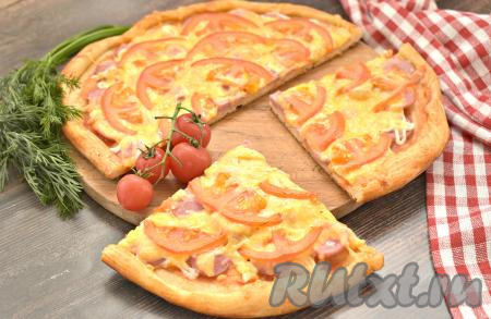 Готовую выпечку достаём из духовки. Пицца с начинкой из сосисок, помидоров и сыра получилась вкусной, сочной и очень аппетитной, разрезаем её на ломтики и угощаемся!