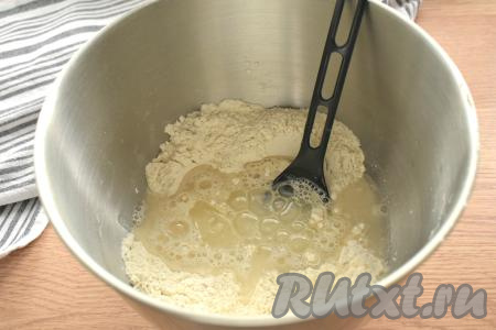 В центр мучной смеси выливаем тёплую кипячёную воду (температура воды должна быть примерно 37 градусов) и 2 столовых ложки растительного масла.