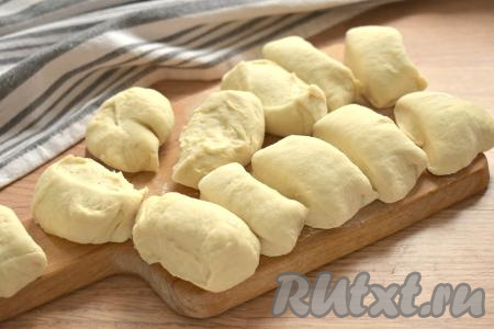 По истечении часа поднявшееся тесто обминаем, делим на 12 равных кусочков.