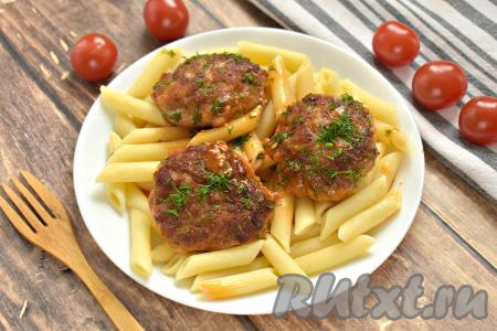 Вкусные, сочные котлеты вместе с томатной подливой перекладываем со сковороды на тарелки и подаём с гарниром к столу (я подала с макаронами).