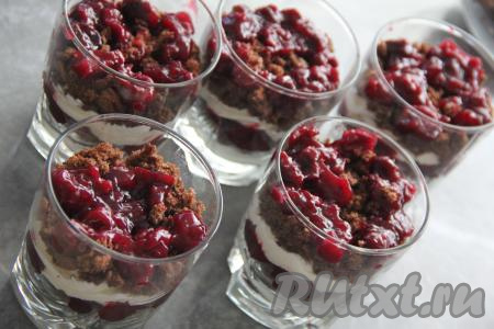 Теперь можно приступать к формированию трайфла "Чёрный лес". Бисквит раскрошить в крошку (это можно сделать вручную или в измельчителе). Я формировала десерт в 5 стеклянных стаканах. В каждый стакан отсадить часть крема (я отсаживала крем из кулинарного мешка, можно выкладывать крем столовой ложкой), выложить часть бисквитной крошки и часть вишнёвой начинки. Таким образом, чередуя и выкладывая слоями крем, бисквитную крошку и вишню, наполнить все стаканы.