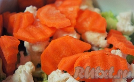 Морковь произвольно нарезать и добавить к капусте. Залить овощи водой и поставить вариться. Когда закипит вода, посолить и варить 5 минут после закипания.