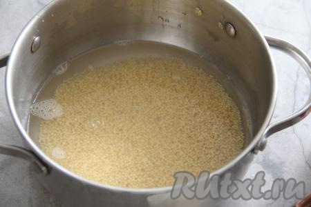 В кастрюлю всыпать промытое пшено, влить 200 миллилитров воды комнатной температуры и поставить на огонь.