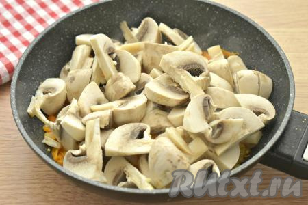 Шампиньоны нарезаем на крупные кусочки, выкладываем к обжаренным овощам, перемешиваем. Обжариваем грибы с морковкой и луком минуты 3-4, не забывая время от времени помешивать.