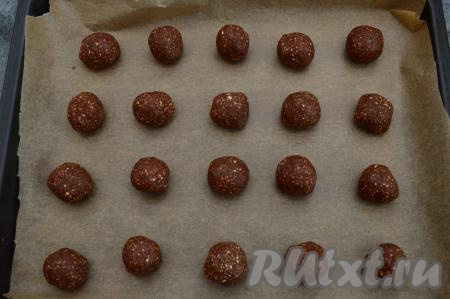 Из шоколадного теста сформировать руками шарики размером с грецкий орех и выложить их на противень, застеленный бумагой для выпечки (я использую силиконизированную пергаментную бумагу, поэтому всегда уверена, что к ней ничего не пристанет в процессе выпечки, если же не уверены в качестве пергамента, тогда слегка смажьте его растительным маслом). Выкладывать шарики нужно на достаточно большом расстоянии друг от друга (примерно 5-6 сантиметров), так как печенье значительно увеличится в процессе выпечки. Всего у меня получилось 20 заготовок.
