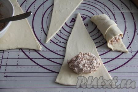 В результате из 2 прямоугольников у нас получатся 4 треугольника. Отступив от основания треугольника примерно 1 сантиметр, выложить часть начинки, как на фото. Я заранее разделила начинку на 4 части (по количеству треугольников).