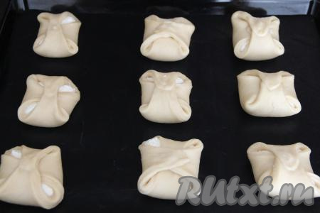 Противень застелить ковриком (или пергаментом) для выпечки. Выложить заготовки ватрушек с творогом на противень на расстоянии 5-6 сантиметров друг от друга и оставить на 30 минут в тёплом месте.