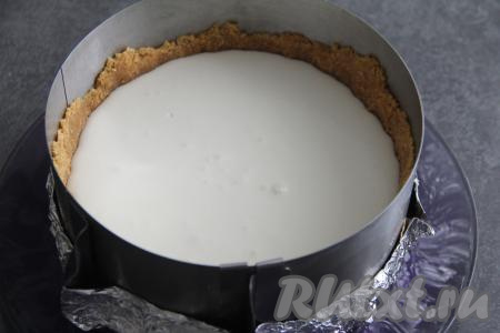 Желатин, набухший в молоке, прогреть на среднем огне, постоянно помешивая, до полного растворения кристаллов желатина и не доводя до кипения (можно прогреть и на водяной бане или в микроволновке). В творожную массу влить желатиновую смесь и взбить блендером до однородного состояния. Влить творожно-желатиновую массу в форму поверх основы из печенья. Поставить чизкейк в холодильник на 2-3 часа (до полного застывания творожной массы).