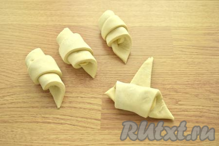 Приступаем непосредственно к формированию слоек. Приподнимаем сторону с разрезом первого треугольника и накрываем ею бананы, сворачиваем тесто в рулетик.&nbsp;Аналогично формируем ещё 3 слойки. Точно также формируем 4 слойки с бананом из второго пласта слоёного теста. Из двух пластов слоёного теста у меня вышли 8 слоек с банановой начинкой.