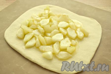 На раскатанное тесто выкладываем ровным слоем грушевую начинку, оставляя края теста свободными.