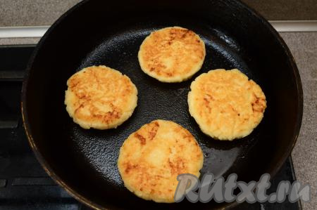 Затем сырники перевернуть на другую сторону, уменьшить немного огонь и жарить под крышкой ещё 2-3 минуты. После этого огонь выключить и оставить сырники пропариться под крышкой в течение 3-5 минут.