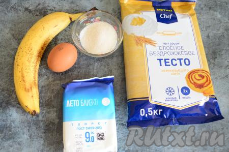 Подготовить продукты для приготовления слоек с творогом и бананом. Слоёное тесто можно взять дрожжевое или бездрожжевое - в данном рецепте это не имеет значения. Тесто следует заранее достать из морозилки, чтобы оно разморозилось при комнатной температуре. Банан лучше всего брать сладкий, спелый.