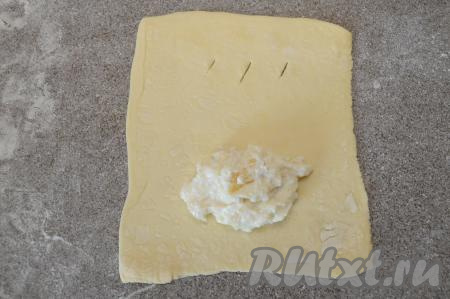 Визуально квадрат разделить на 2 половинки. На одну половину квадрата выложить столовую ложку начинки из творога и банана. На другой половинке сделать 3 небольших разреза (эти разрезы нужны для выхода пара при выпечке).